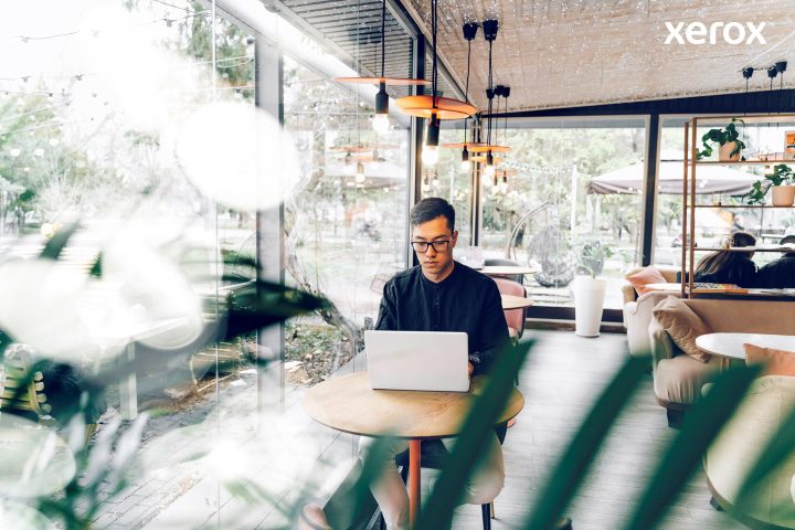 A man diligently working on his laptop in a bustling cafe, immersed in his tasks amidst a lively environment. A man diligently working on his laptop in a bustling cafe, immersed in his tasks amidst a lively environment.