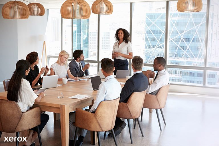 A woman stands before a group, confidently presenting her topic and interacting with the audience during the session. A woman stands before a group, confidently presenting her topic and interacting with the audience during the session.