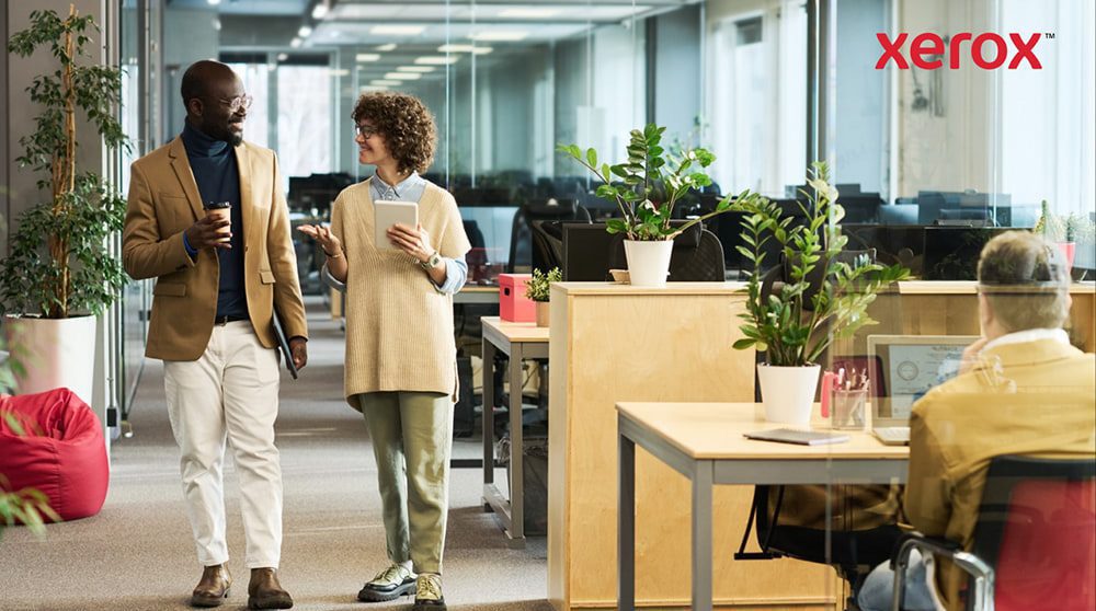 Two professionals walking and talking in a modern office Two professionals walking and talking in a modern office